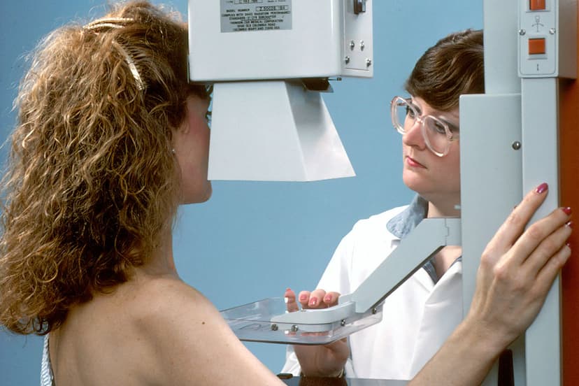A technologist positions a patient for a mammogram.